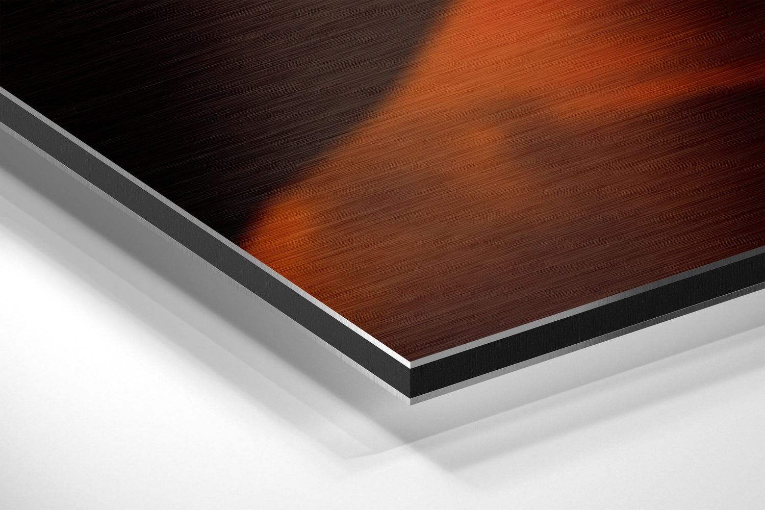 Close-up angled view of layered Dibond panel showing red-brown brushed metal surface with black and silver edge layers against white background.