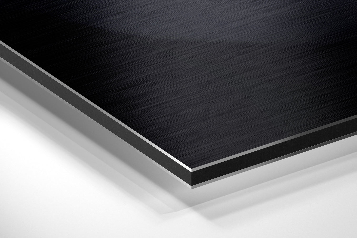 Close-up angled view of layered brushed black aluminum and white composite material edges showing product construction and finish.