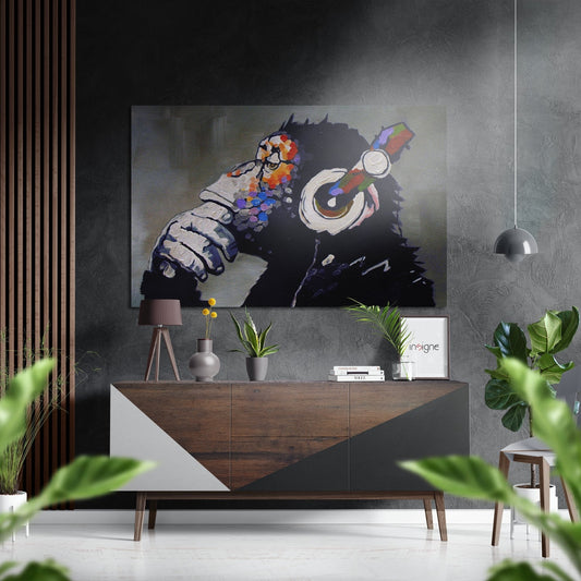 Modern living room interior featuring "Ape the Thinker" street art metal wall print above wooden sideboard with plants and accessories.