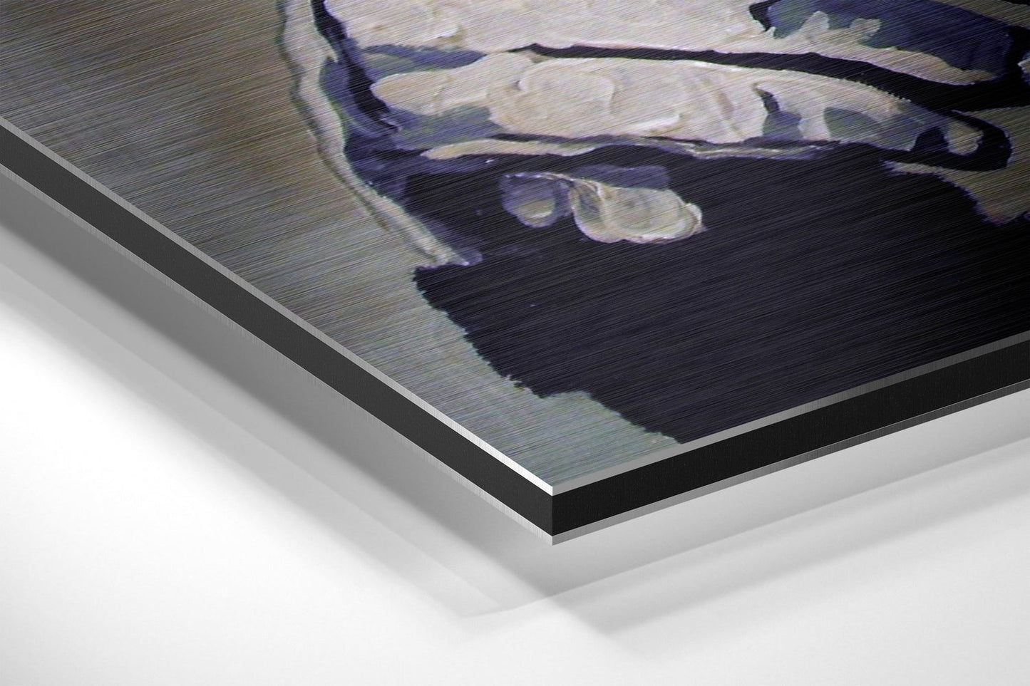 Close-up angled view of brushed aluminium Dibond wall art showing layered black and silver metal edges with a primate figure printed on the surface.