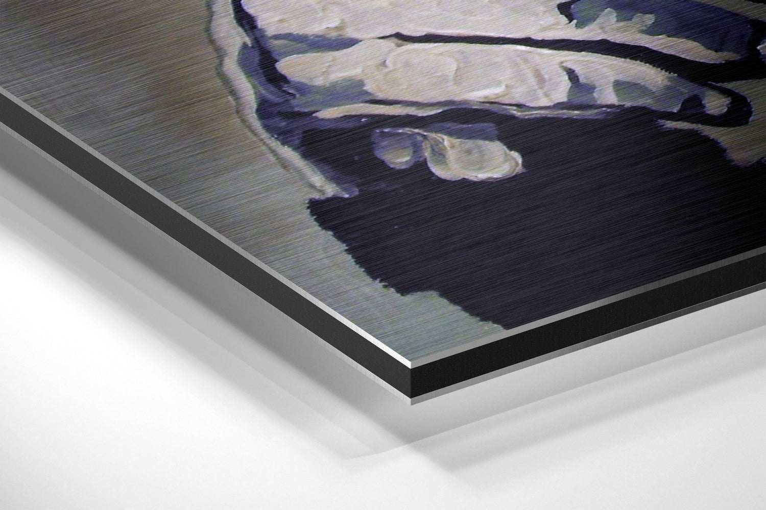Close-up angled view of brushed aluminium Dibond wall art showing layered black and silver metal edges with a primate figure printed on the surface.