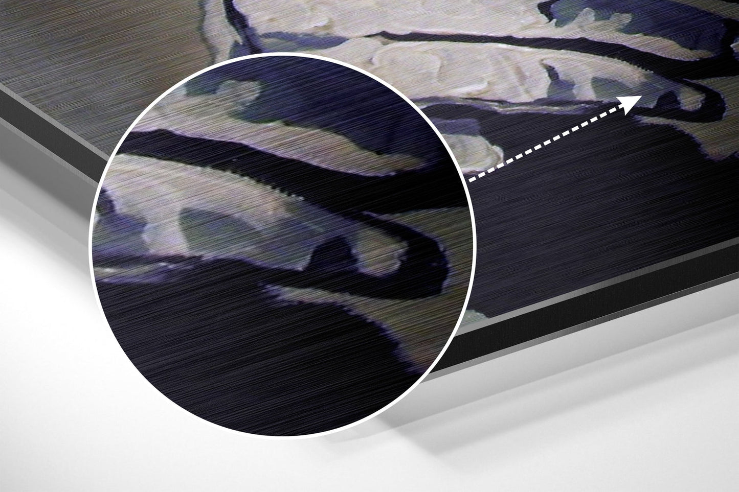 Close-up of brushed aluminium surface showing dark sculptural figure with blue and grey tones against metallic texture.