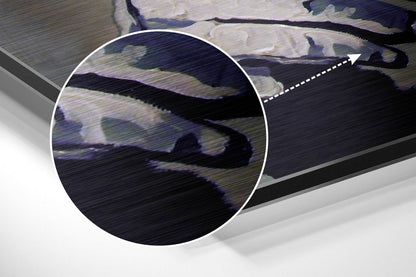 Close-up of brushed aluminium surface showing dark sculptural figure with blue and grey tones against metallic texture.
