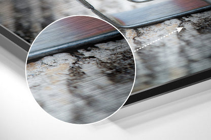 Close-up detail of brushed aluminum surface showing wood grain texture and metallic finish with brown and gray tones.