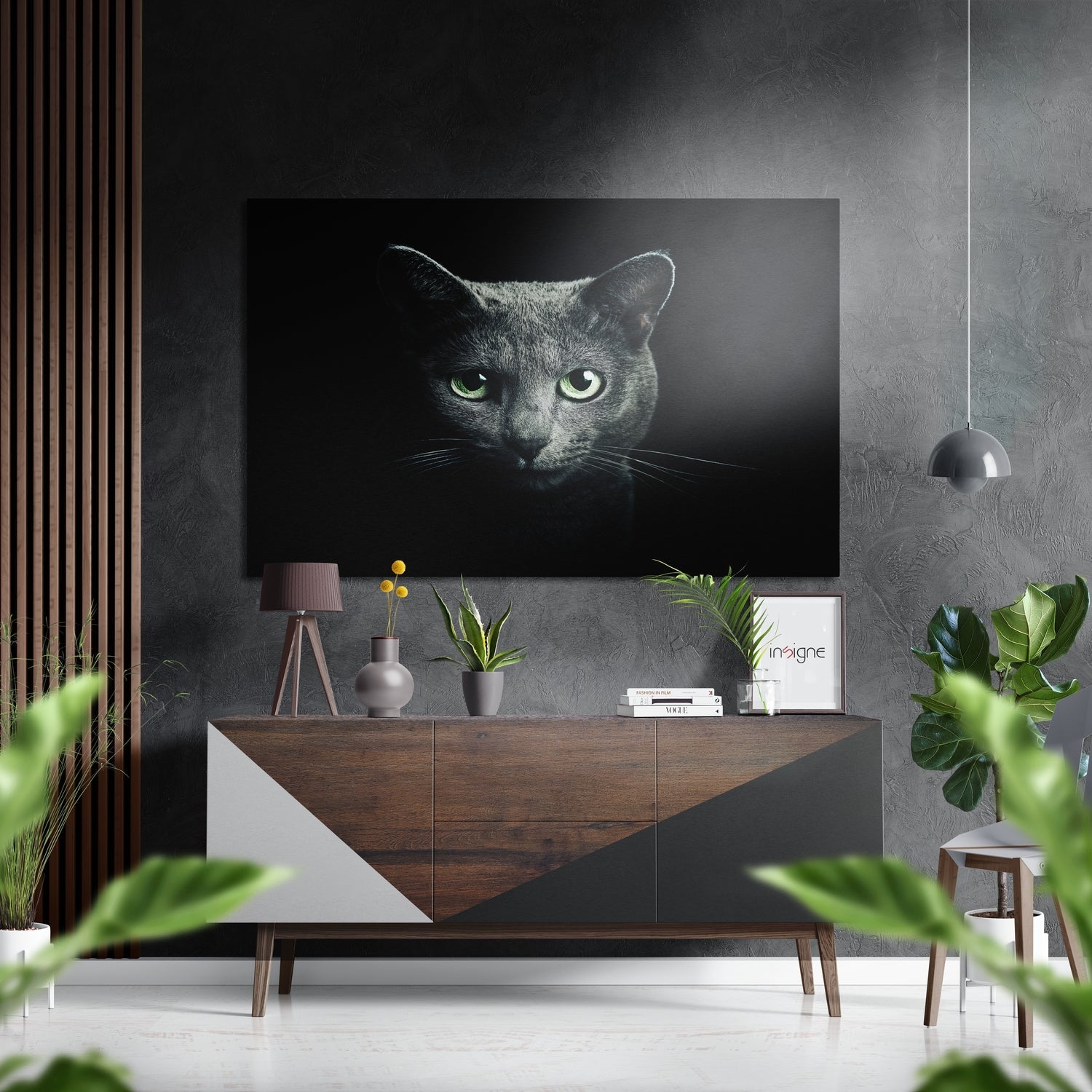 Modern living room interior featuring a dark cat portrait with glowing green eyes mounted on gray textured wall above wooden sideboard with plants and decor.