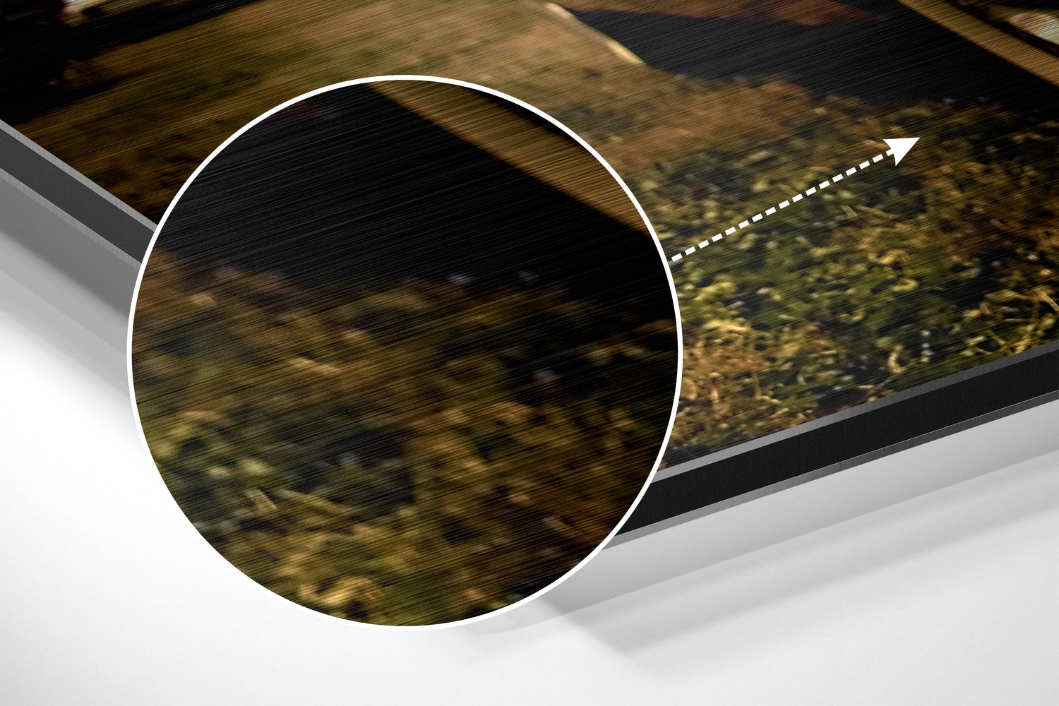 Close-up detail of brushed aluminium surface with circular white-bordered cutout revealing textured wood grain background and directional arrow.