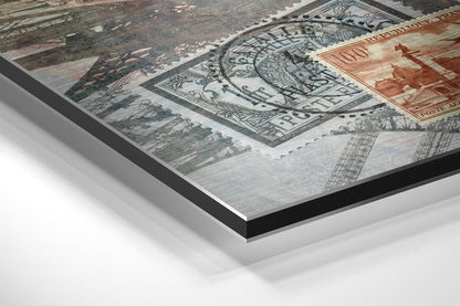 Close-up angled view of brushed aluminium Dibond wall art showing vintage postage stamps and sepia-toned architectural imagery with layered panel edge detail.