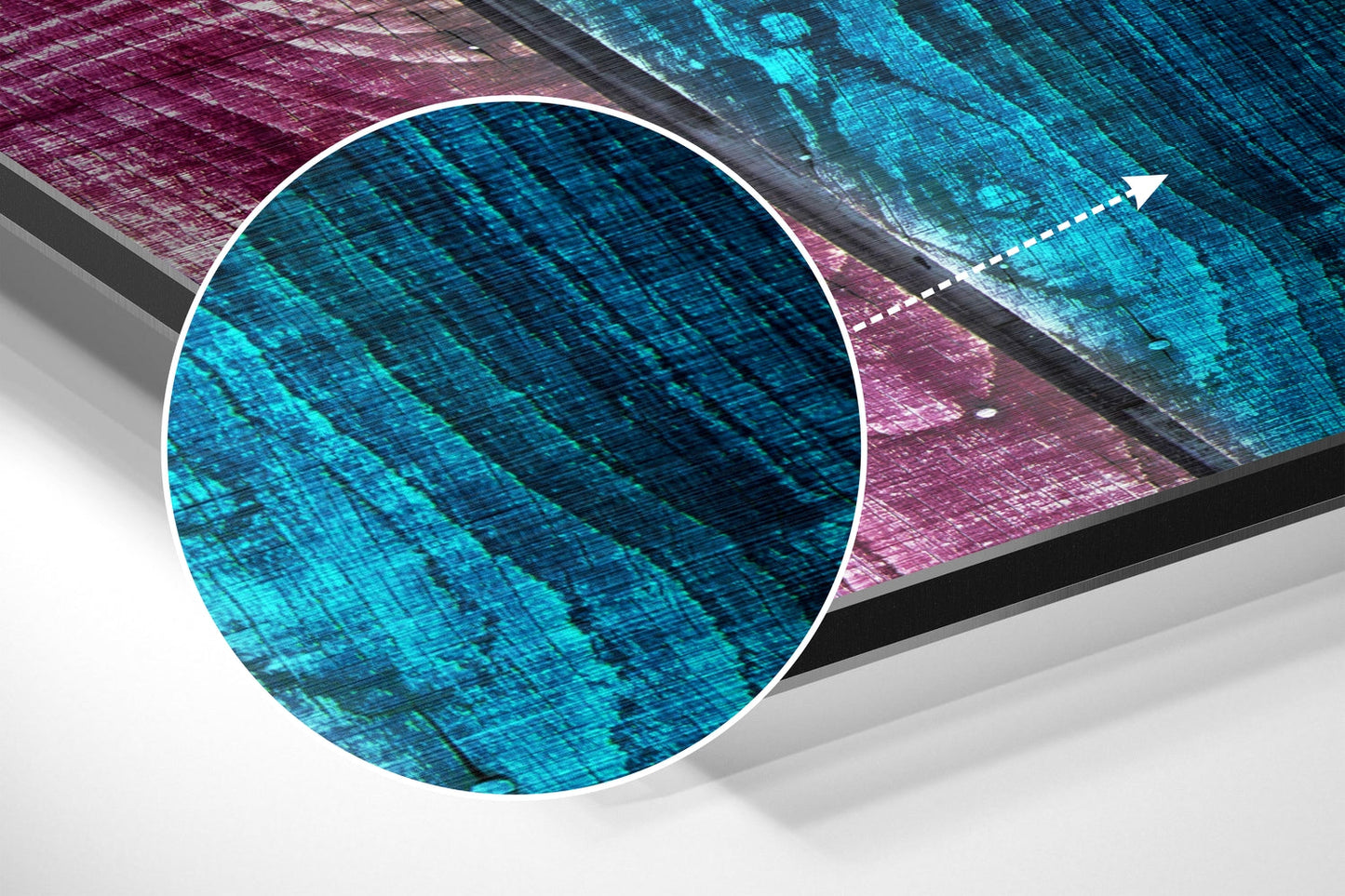 Close-up angled view of brushed aluminum wall art with cyan and magenta geometric patterns and diagonal striations.
