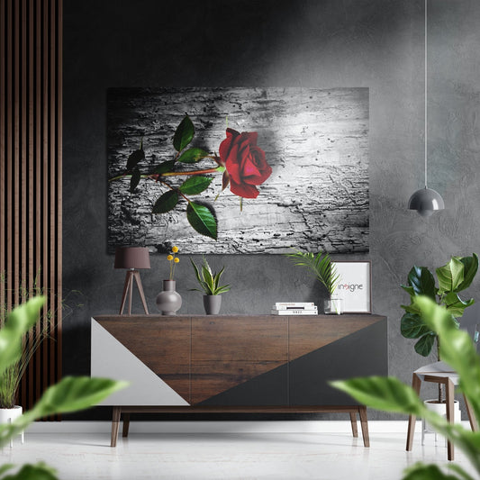 Red rose with green leaves on weathered white wood texture displayed above mid-century modern wooden dresser in styled interior.