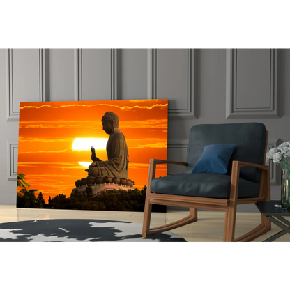 Golden Buddha silhouette in glass wall art against orange sunset