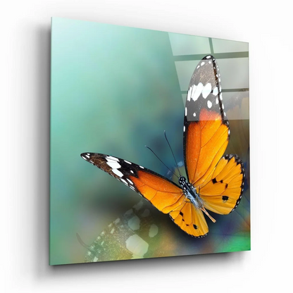 Vibrant orange black butterfly glass wall art with white spots and rainbow glow