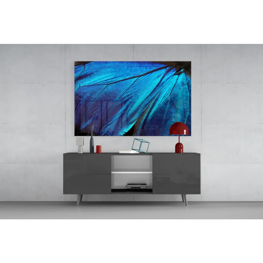 Vibrant blue butterfly wing glass wall art above gray console