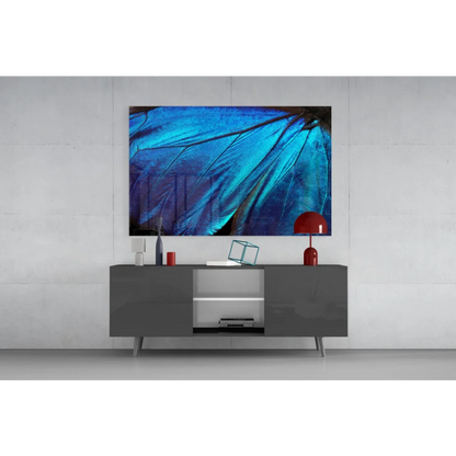 Vibrant blue butterfly wing glass wall art above gray console