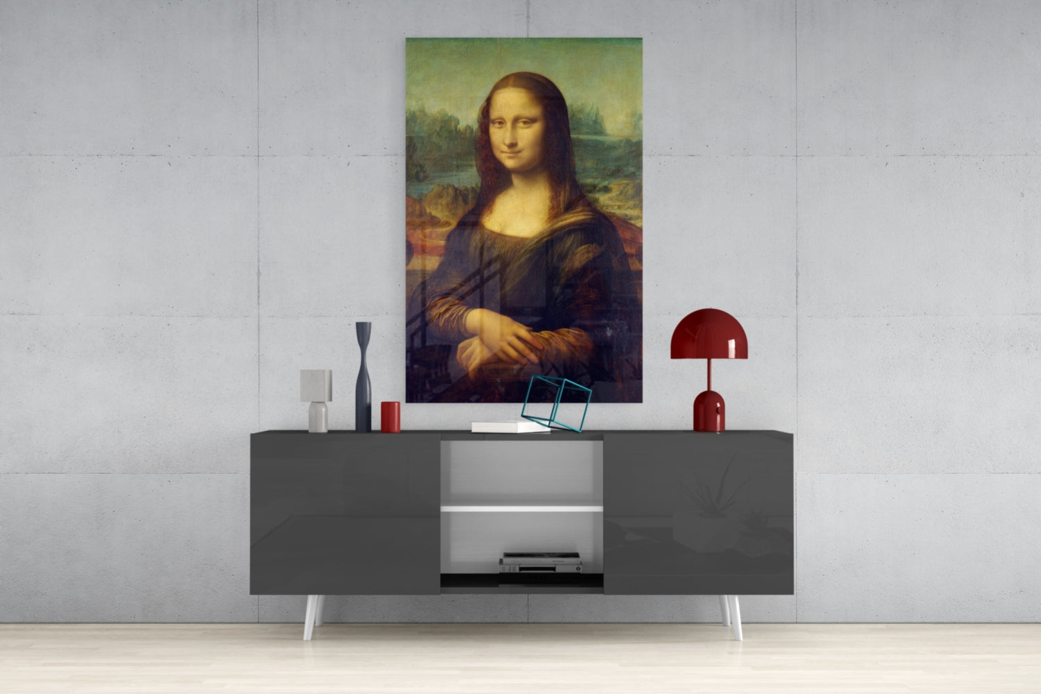 Mona Lisa glass wall art displayed above a gray console table with white legs, styled with decorative objects including a red lamp and small sculptures.