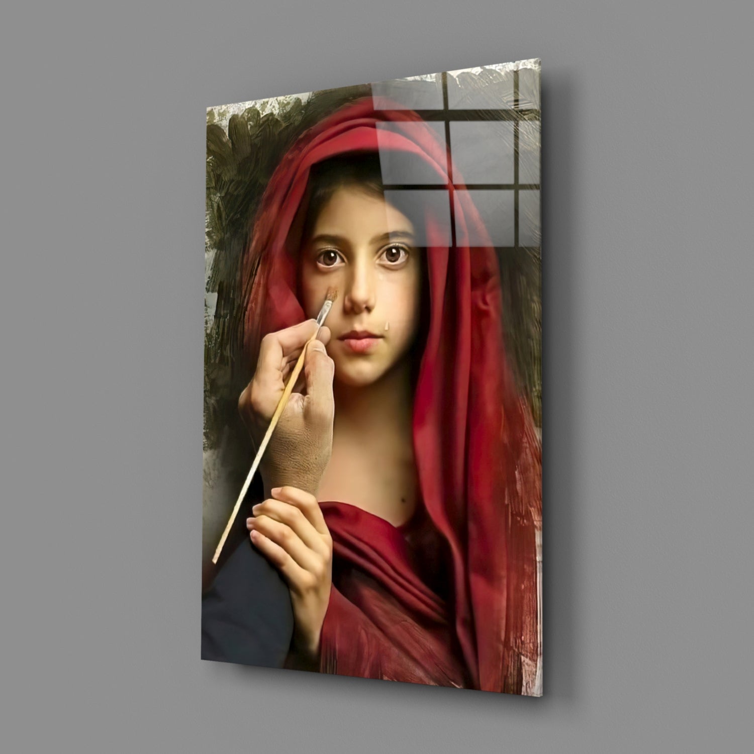 Glass wall art displaying a young girl in a red headscarf holding a paintbrush, mounted at an angle against gray background.