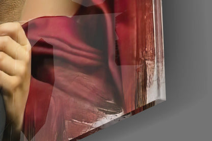 Close-up of hand holding translucent burgundy glass panel showing layered red tones and wood grain texture beneath.
