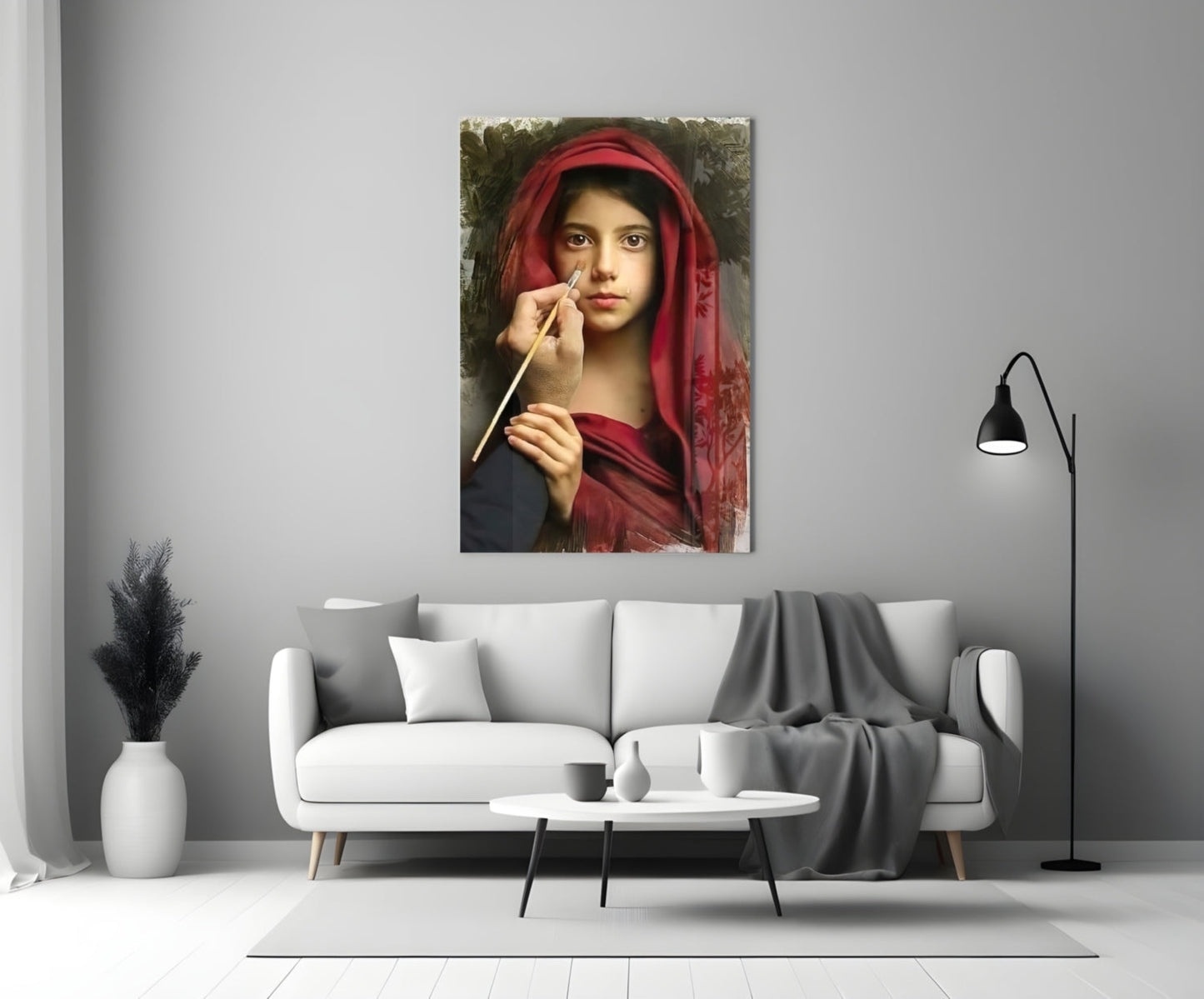 Portrait glass wall art depicting a young woman in red fabric holding a paintbrush, displayed above a modern white sofa.