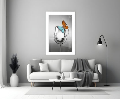 Framed wall art print showing a wine glass with splashing water in black and white, topped with colorful orange and blue butterflies.