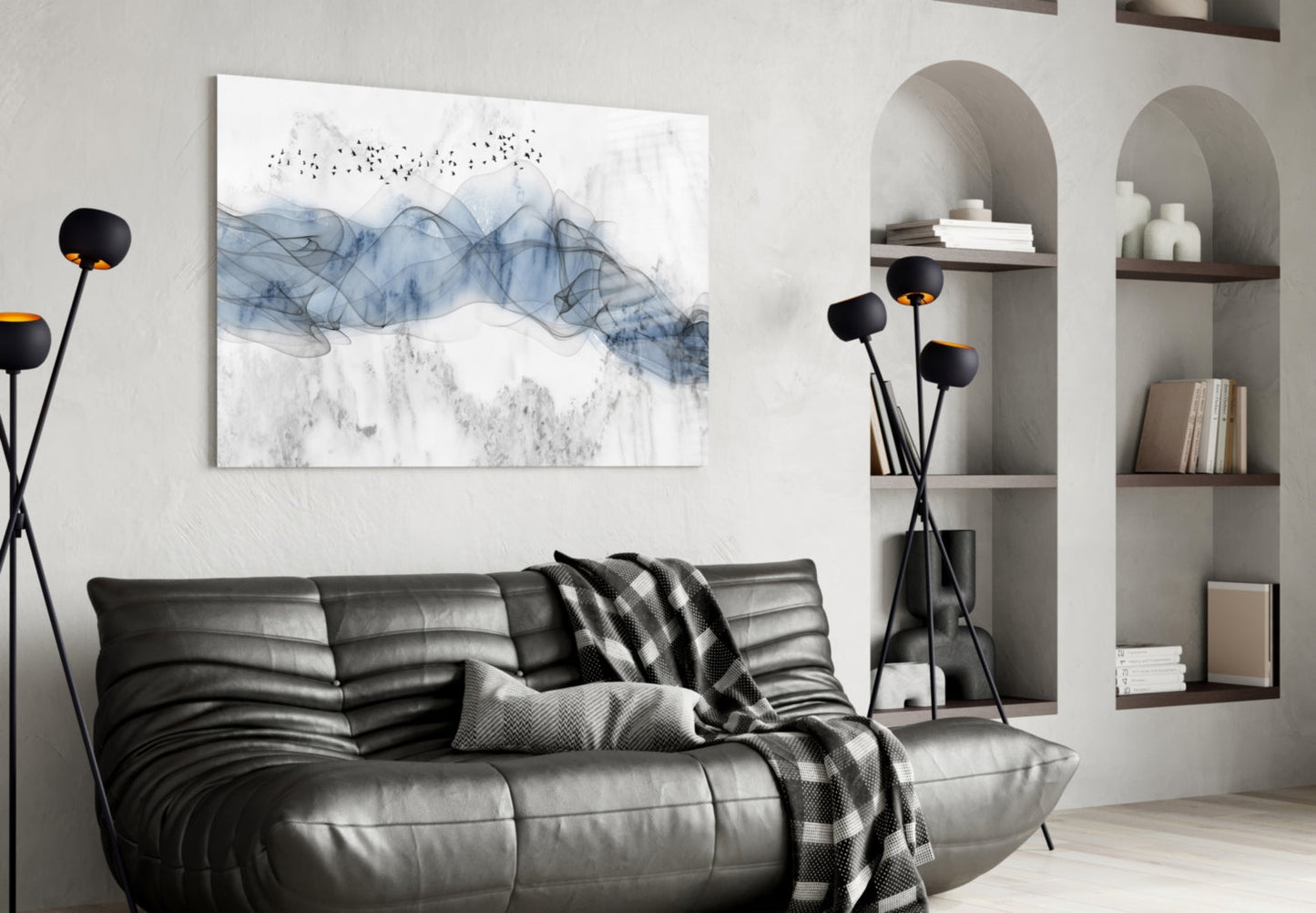 Blue Fog glass wall art with abstract blue and gray flowing patterns and birds displayed above black leather sofa in modern living room setting.