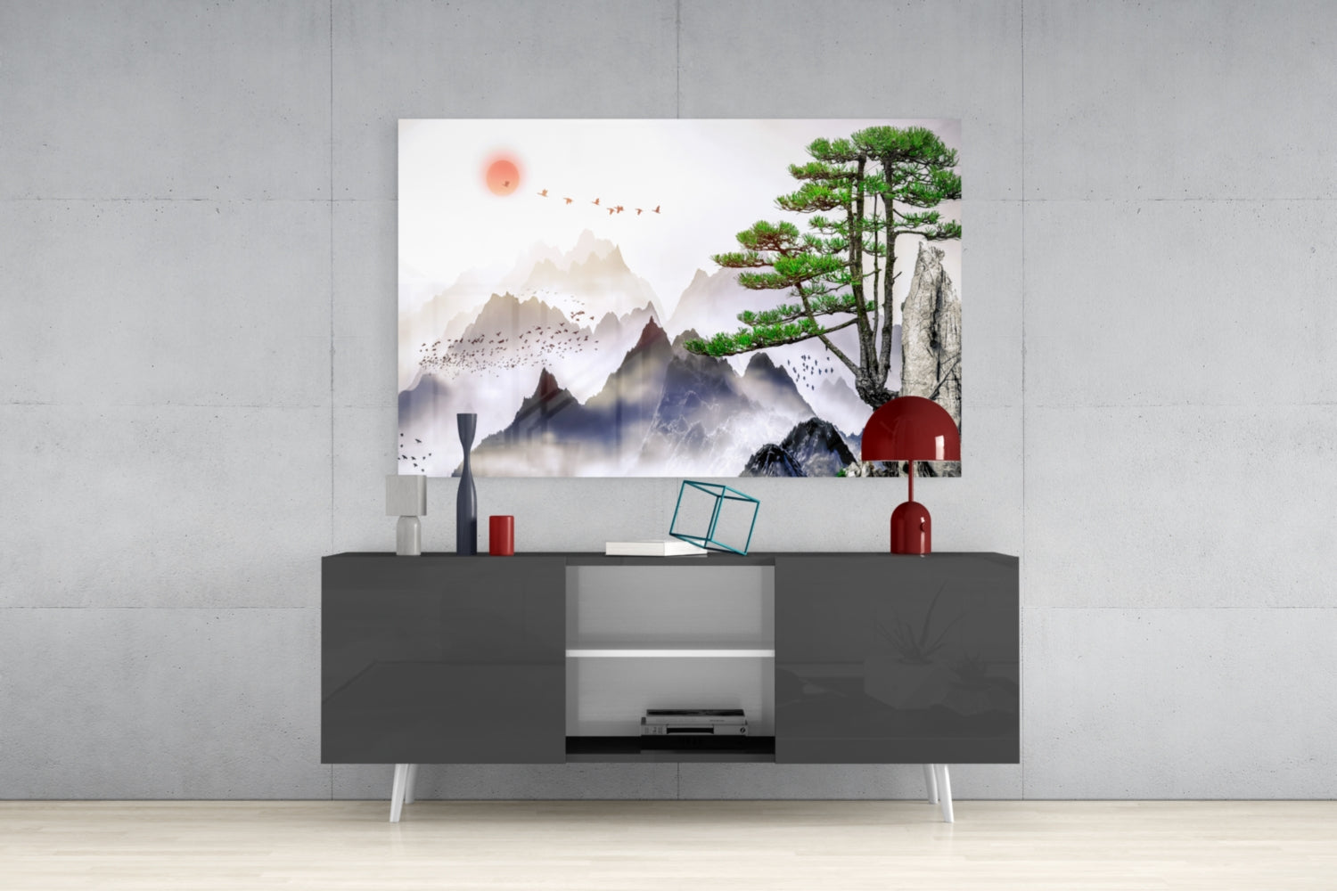 Modern living room setup featuring abstract forest glass wall art with misty mountains, red sun, and green pine tree displayed above a gray media console.
