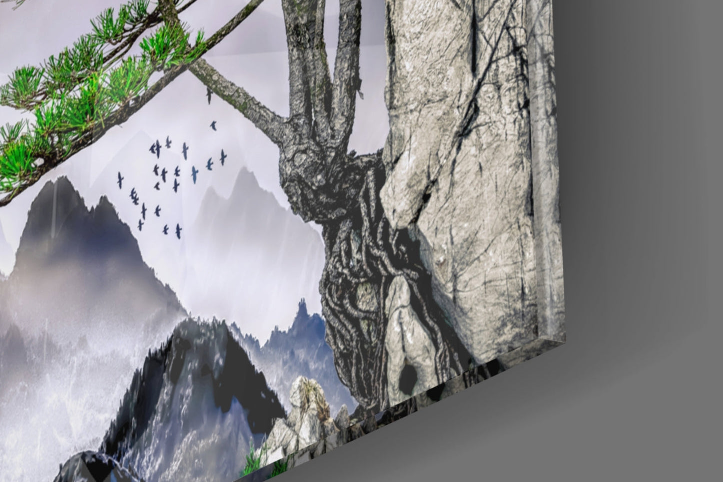 Glass wall art panel displaying misty mountains, evergreen trees, flying birds, and textured rock formations in gray and blue tones.