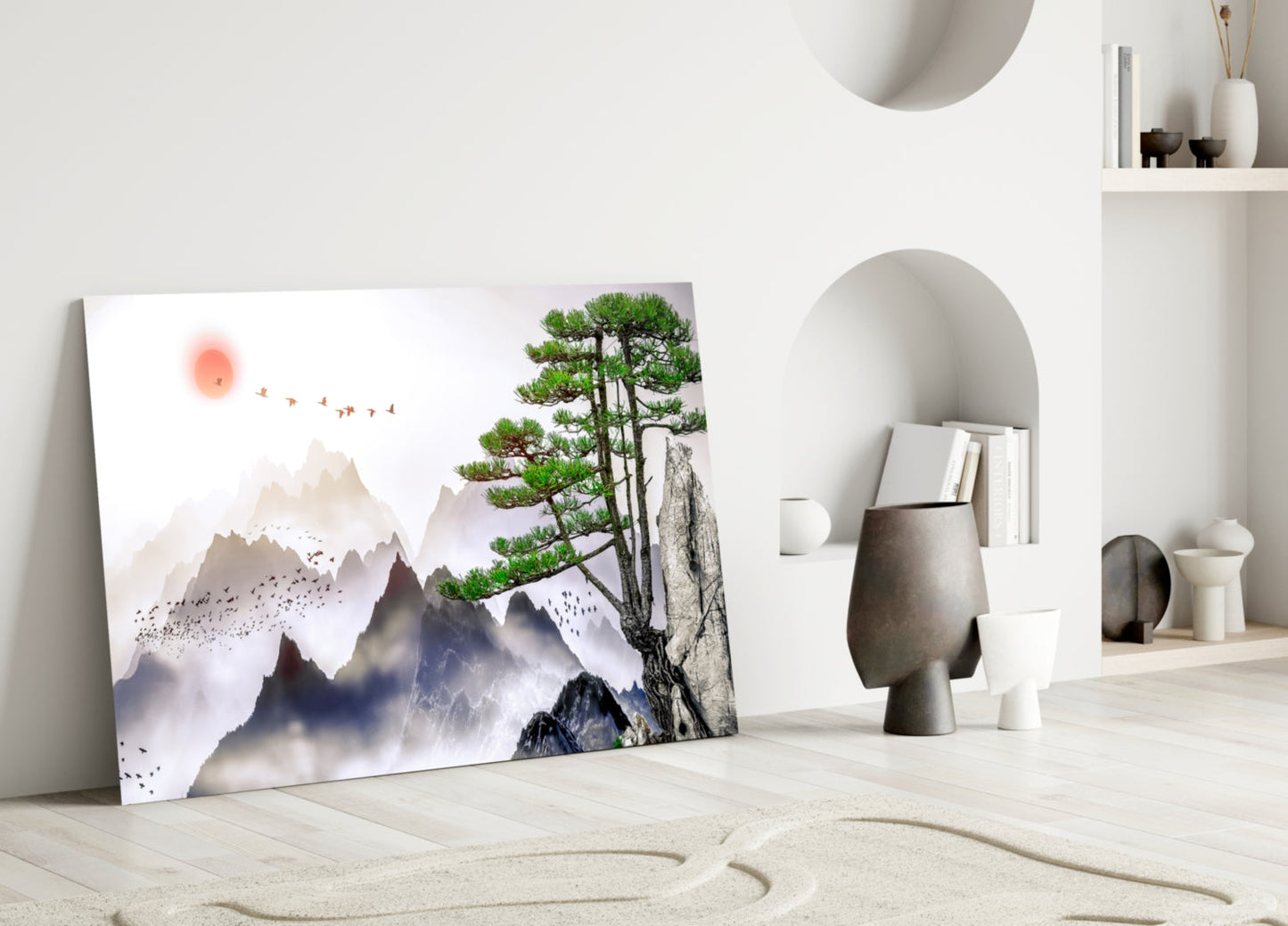 Abstract forest glass wall art leaning against white wall in minimalist interior with mountains, bonsai tree, and red sun design.