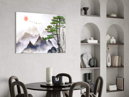Abstract forest glass wall art depicting misty mountains, tall pine tree, and red sun displayed above black dining table in modern interior.