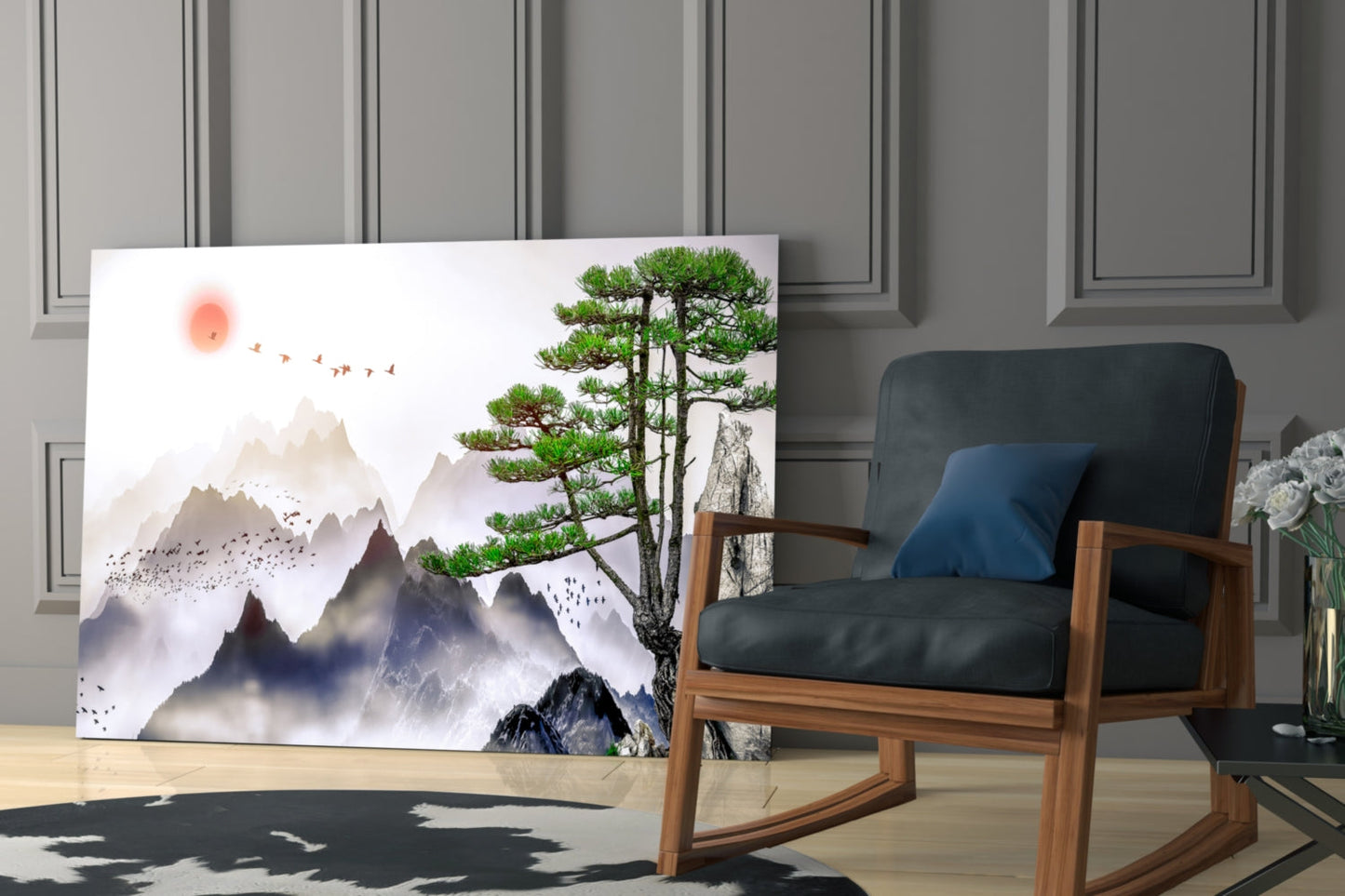Abstract forest glass wall art leaning against paneled wall beside wooden chair, depicting misty mountains, pine tree, and birds in muted tones.