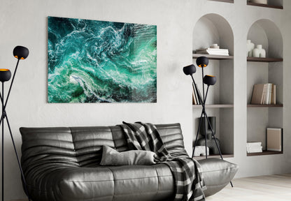 Green Waves glass wall art displayed above black leather sofa in modern living room with white shelving.