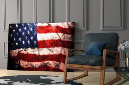 Distressed American flag glass wall art displayed in a modern living room beside a wooden rocking chair with dark cushions.
