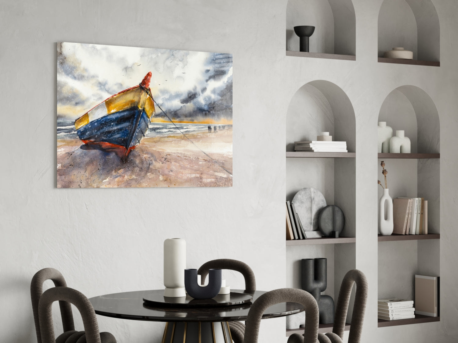 Colorful fishing boat painting displayed on white wall above black dining table with gray chairs and built-in shelving.
