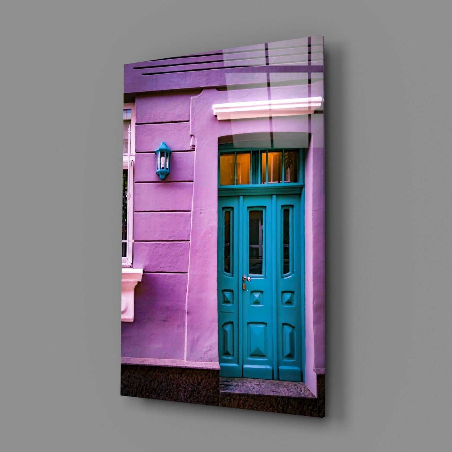 Glass wall art displaying a vibrant purple building facade with turquoise door and teal lantern, mounted at an angle.