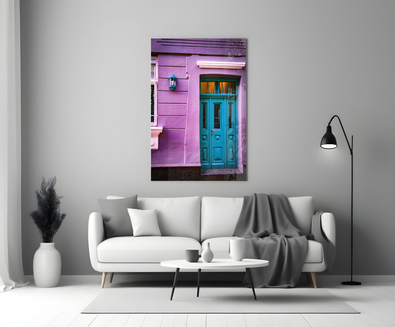Purple House Glass Wall Art displayed above white sofa showing vibrant pink building facade with turquoise door.