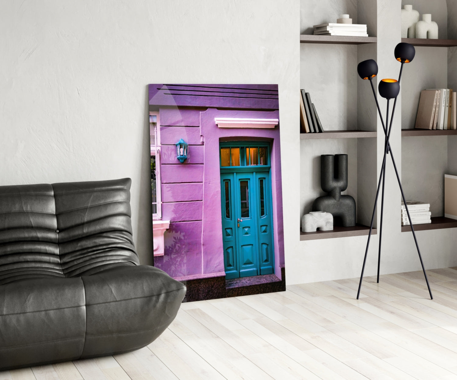 Modern living room with purple house glass wall art displayed between black leather chair and white shelving unit with black floor lamp.