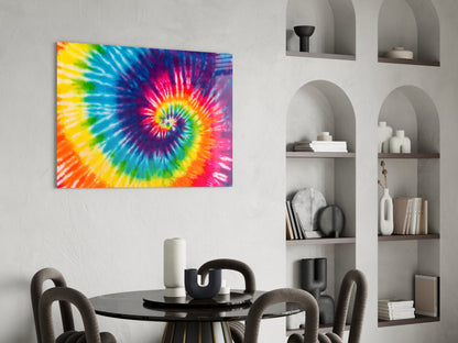Vibrant tie-dye spiral glass art hanging above black round dining table with gray chairs and white shelving unit.