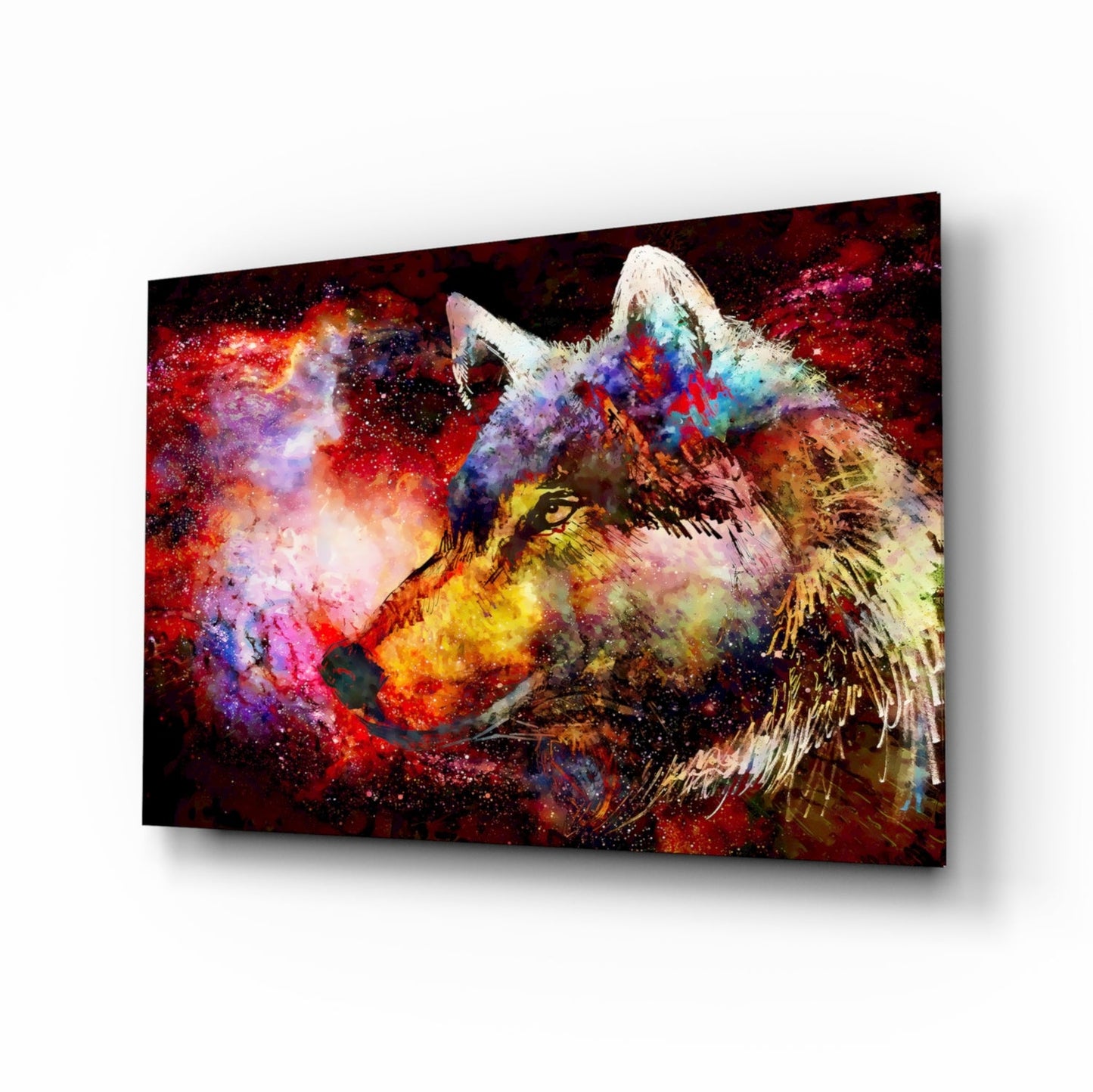Angled view of a glass wall art panel displaying a colorful wolf's head with vibrant red, purple, blue, and yellow paint splatters against a dark background.