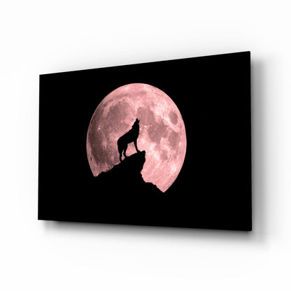 Black glass wall art panel displaying a silhouetted wolf howling on a rocky outcrop against a large pink full moon.