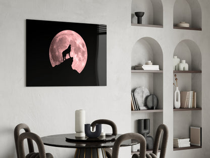 Wolf and full moon glass wall art displayed above a black dining table in a minimalist room with built-in shelving.