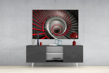 Red and gray spiral staircase glass wall art displayed above gray media console in modern interior setting.