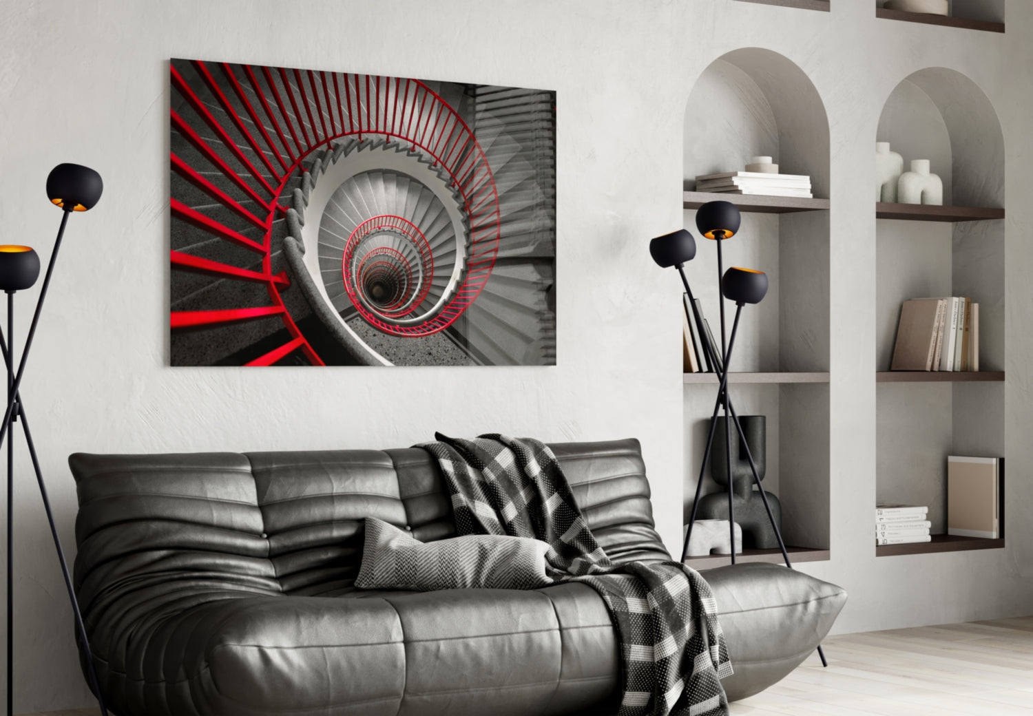 Modern living room with red and gray spiral staircase glass wall art above black leather sofa.