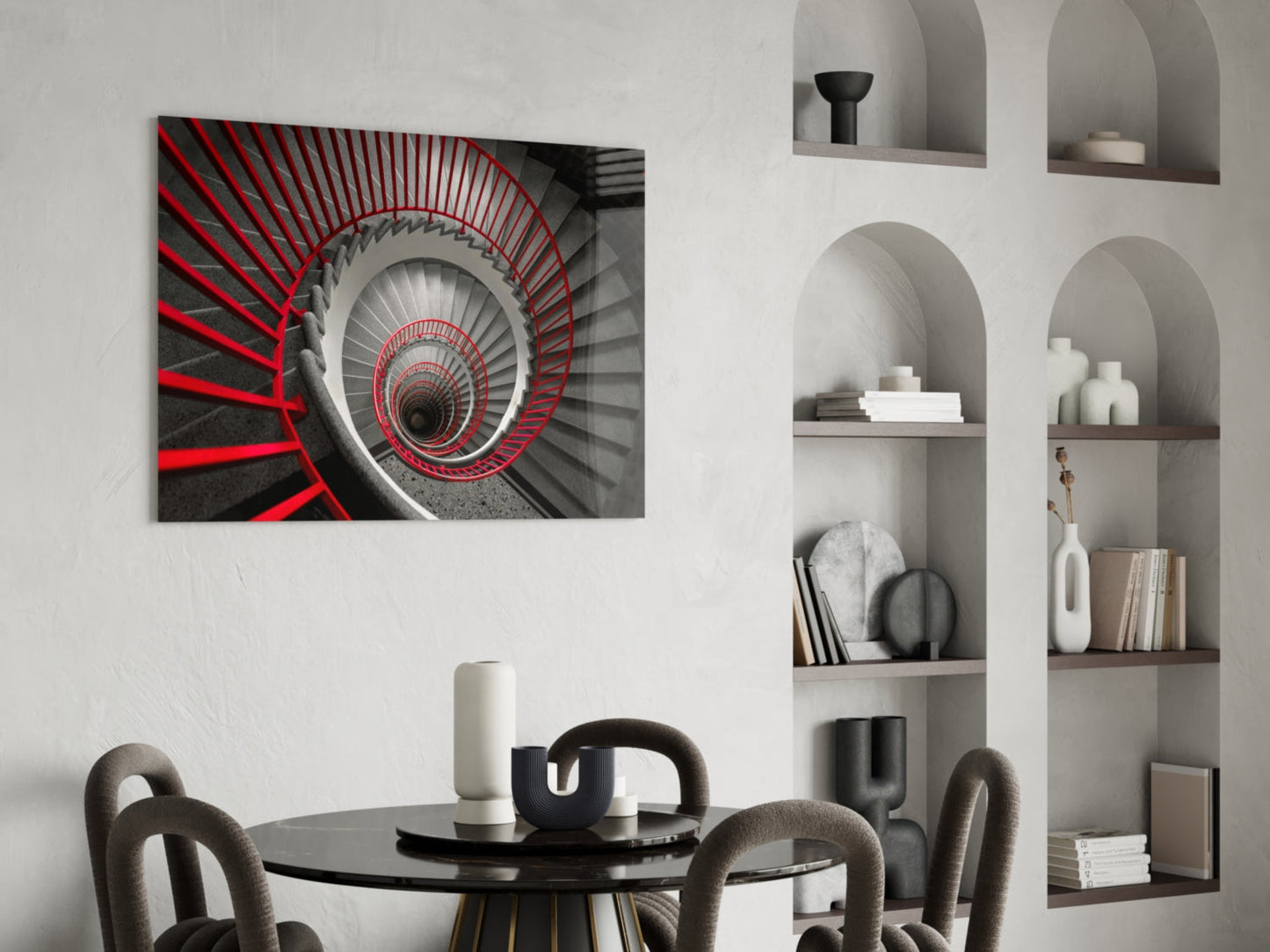 Red and gray spiral staircase glass wall art displayed above black round dining table in modern interior with built-in shelving.