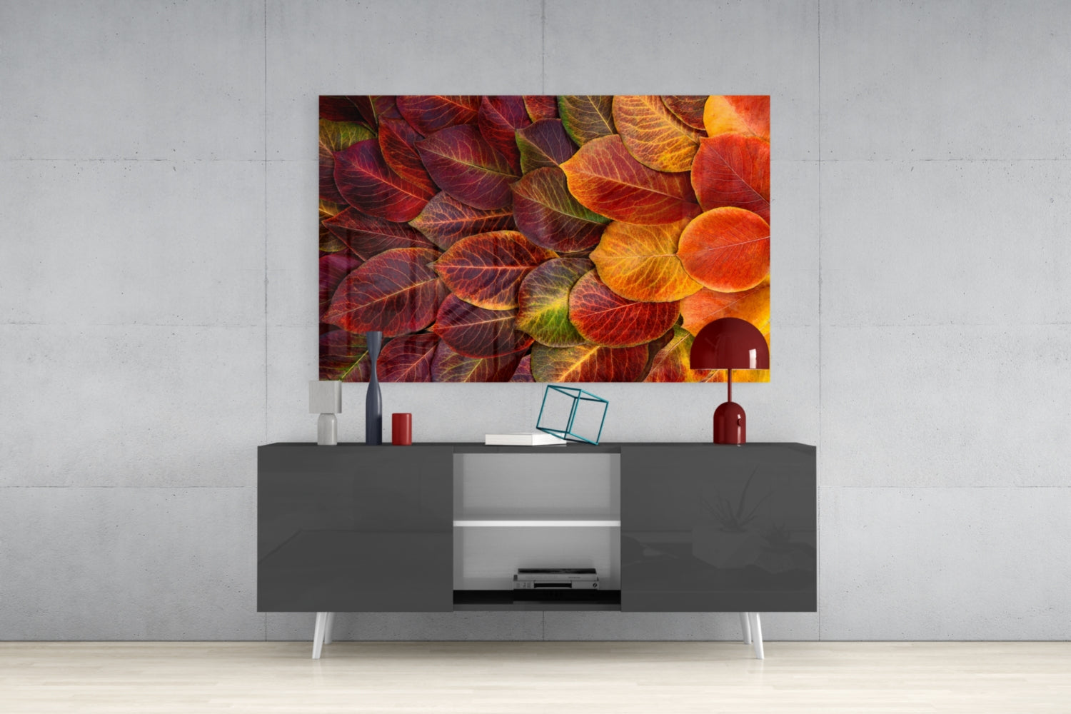 Orange Leaves Glass Wall Art mounted above a dark gray TV console with white legs in a minimalist living room setting.