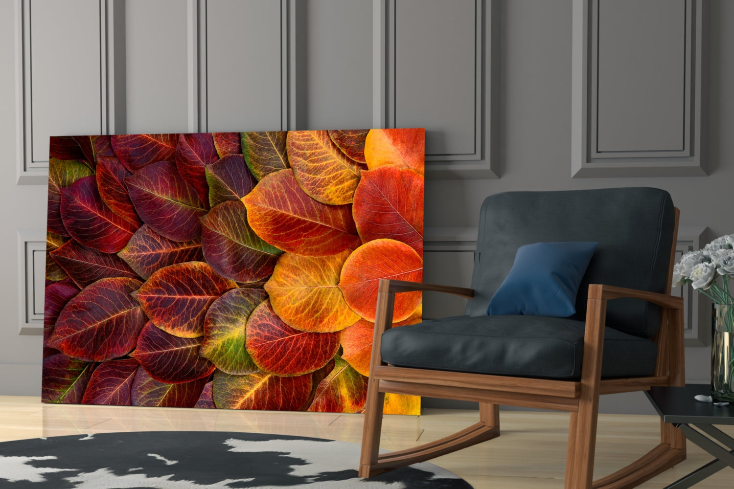 Autumn leaves glass wall art displayed in modern living room beside wooden rocking chair with black leather cushion.
