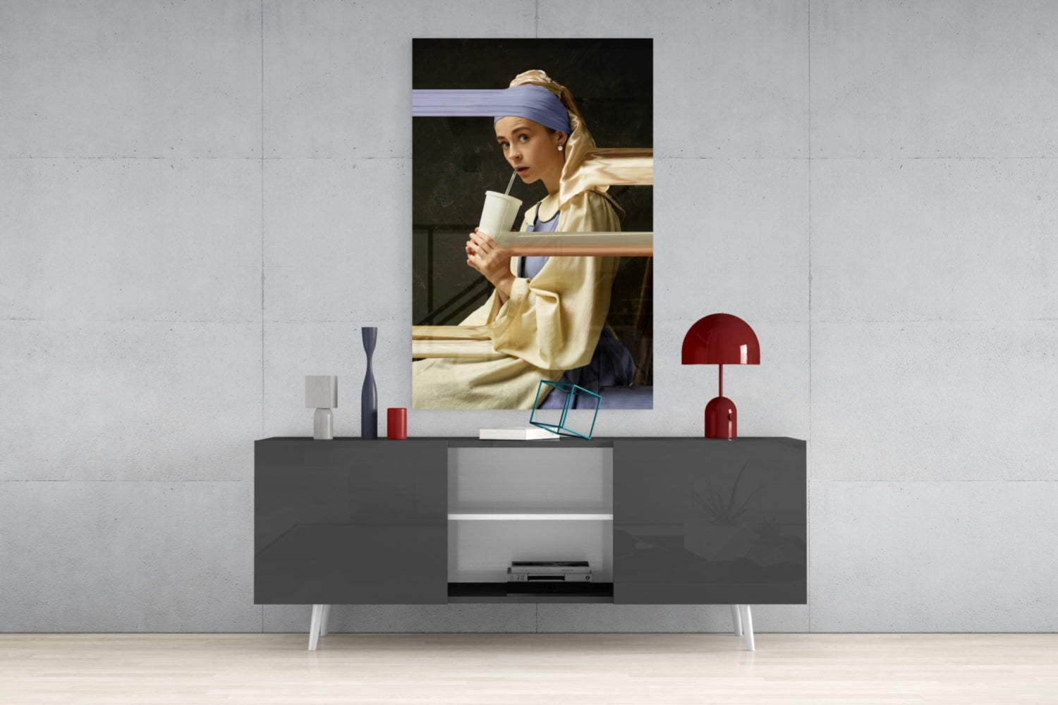 Girl with a Pearl Earring glass wall art displayed above a dark gray console table with decorative objects and open shelving.