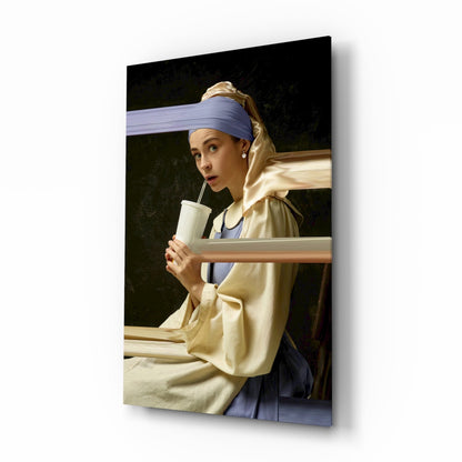 Glass wall art panel showing a woman in yellow garment and blue headwrap holding a white cup, angled three-quarter view.