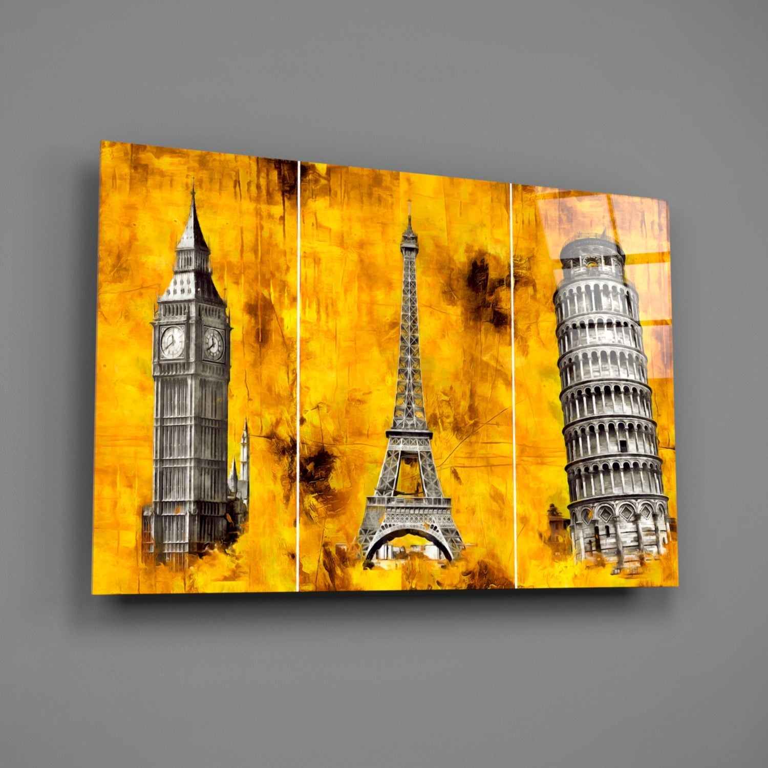 Three-panel glass wall art displaying Big Ben, Eiffel Tower, and Leaning Tower of Pisa against vibrant golden yellow textured background.