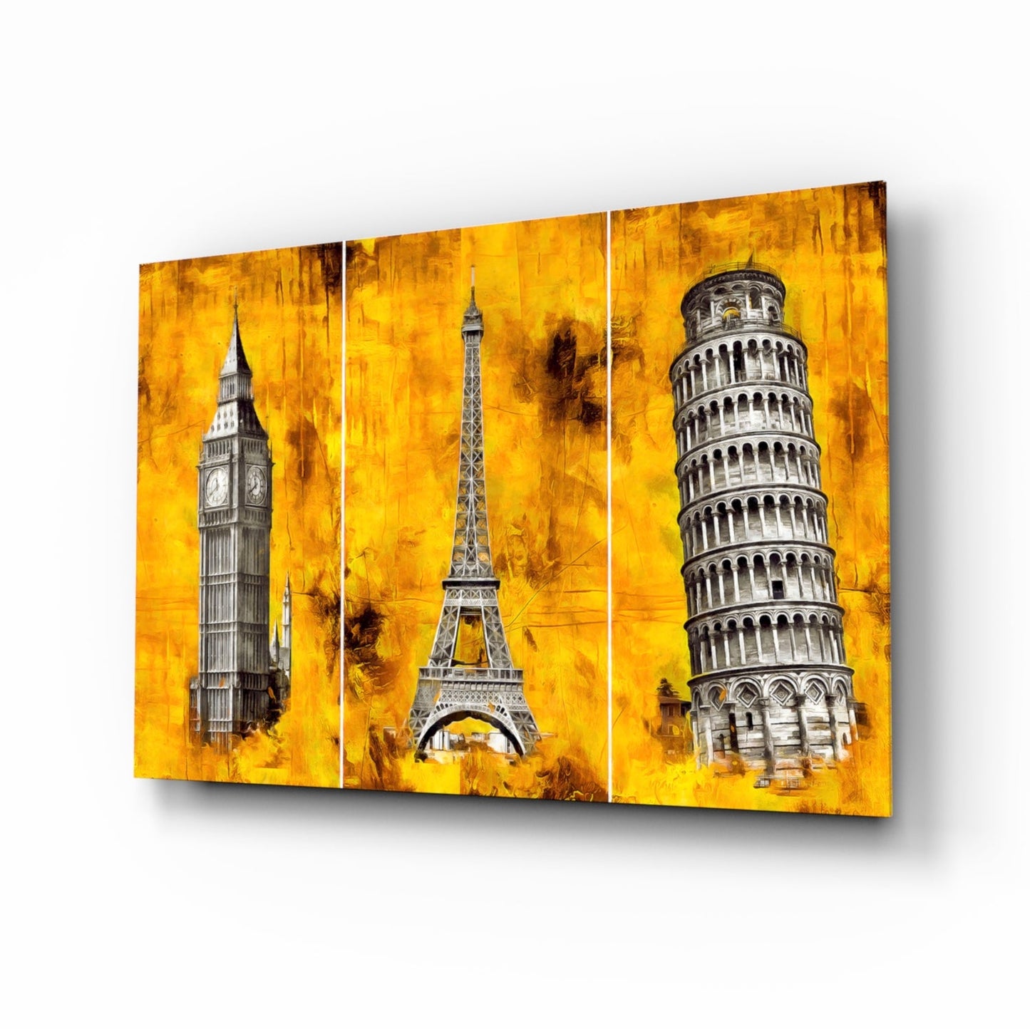 Three-panel glass wall art featuring Big Ben, Eiffel Tower, and Leaning Tower of Pisa against a textured golden yellow background, displayed at an angle.