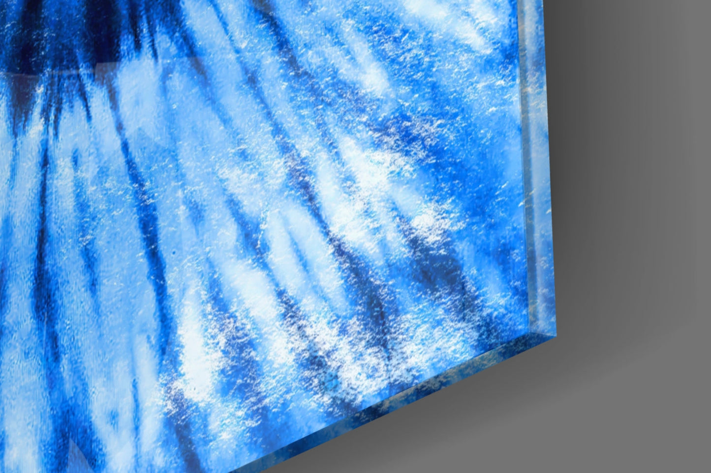 Close-up angled view of blue mosaic glass wall art showing textured surface with white and dark blue streaks against gray background.