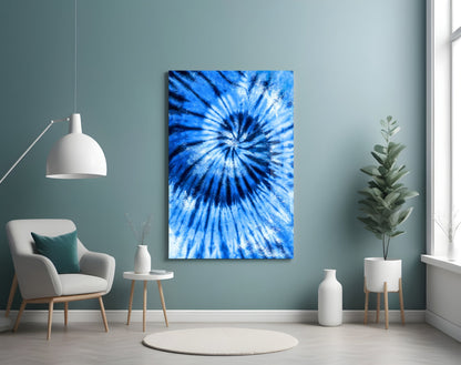 Blue mosaic glass wall art with radial starburst pattern displayed in minimalist room setting with chair and plants.