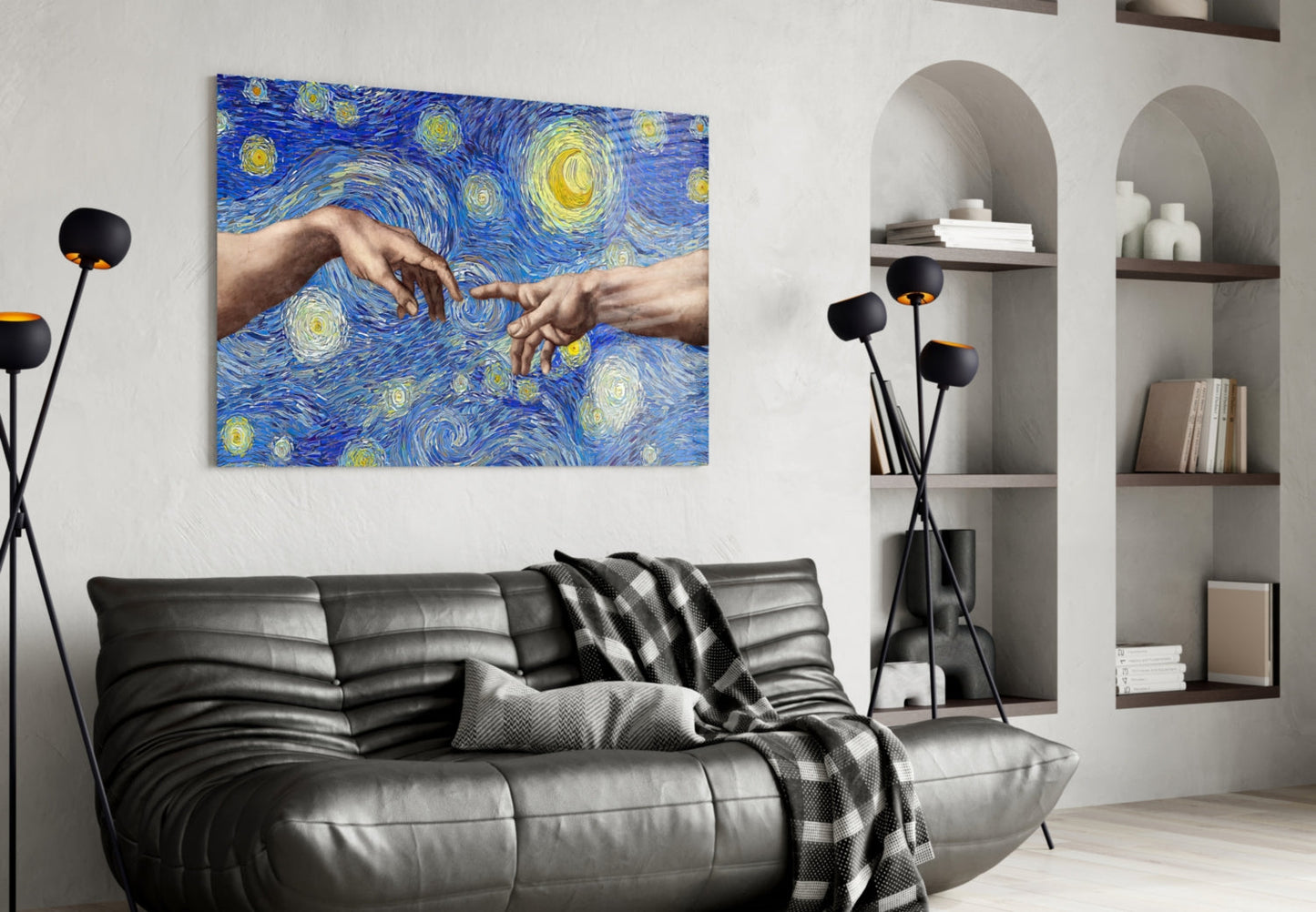 Modern living room with black leather sofa displaying glass wall art featuring two hands touching against blue starry background with yellow swirls.
